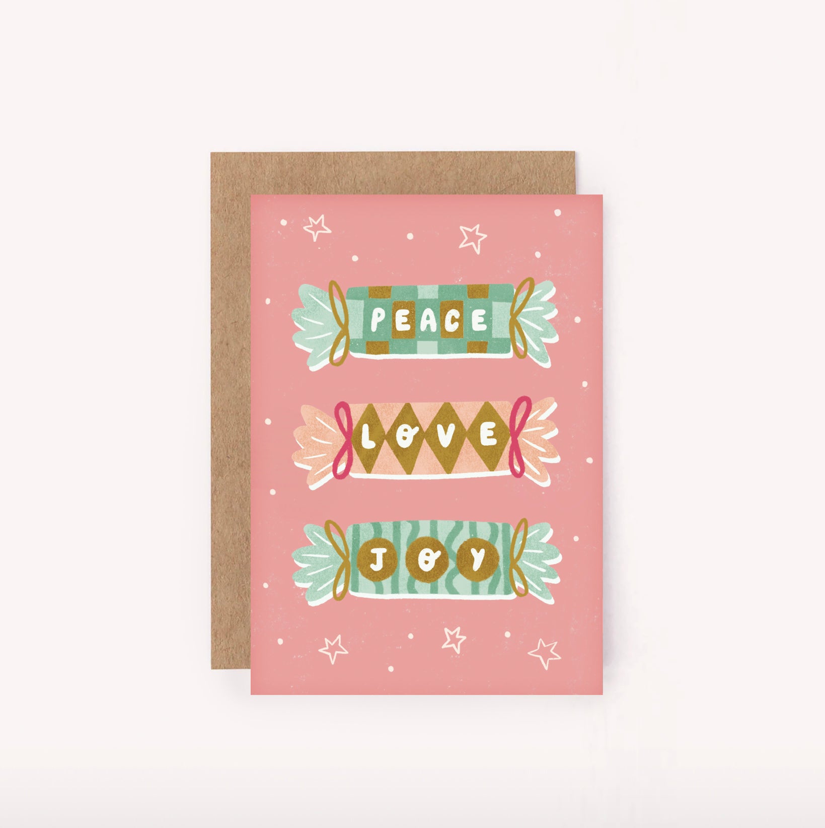 Send some Peace, Love & Joy with this illustrated mini Christmas card. Features three pink, gold and green boldly patterned Xmas crackers, tied with ribbons and hand-lettered "Peace" "Love" "Joy" set upon a pink background