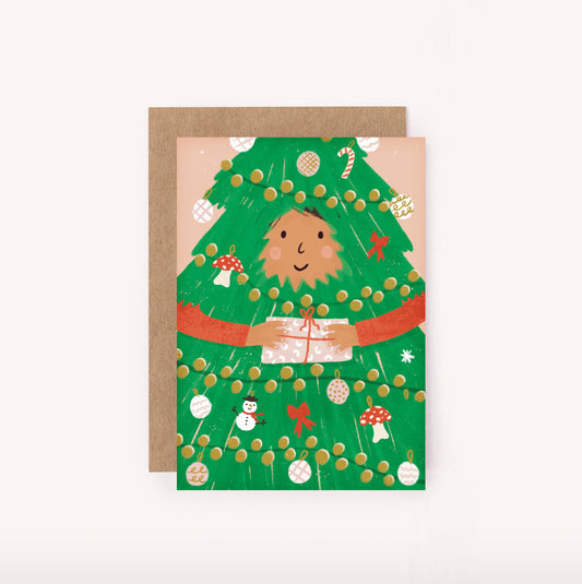 This fun festive Christmas mini card is a smaller version of our bestselling Christmas design. It features a girl holding a wrapped gift, dressed as a Christmas tree. Candy canes, mushrooms, ribbons and bauble decorations