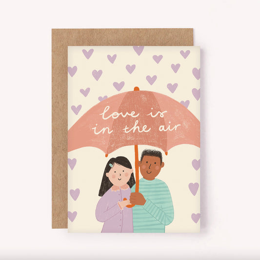 Illustrated "Love is in the Air" greeting card, featuring a cute couple being showered with mini love hearts. Perfect for a newly engaged couple, saying Happy Anniversary, Valentines Day or simply sending some LOVE