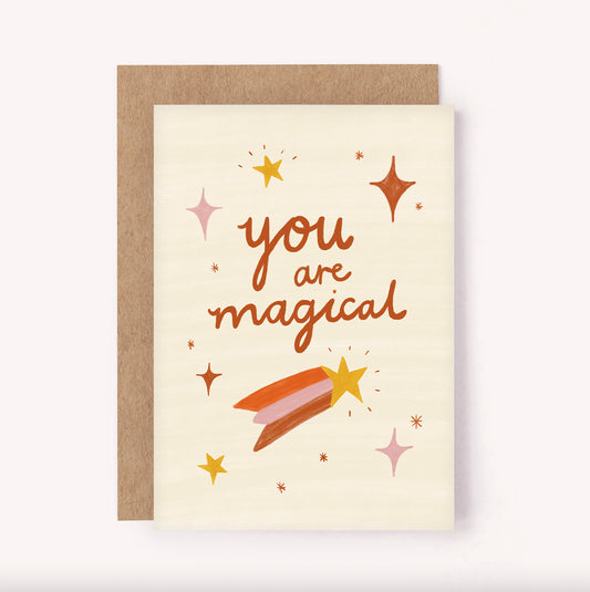 "You are Magical" sparkles and shooting stars greeting card. Beige background with illustrated pink, orange and brown design.